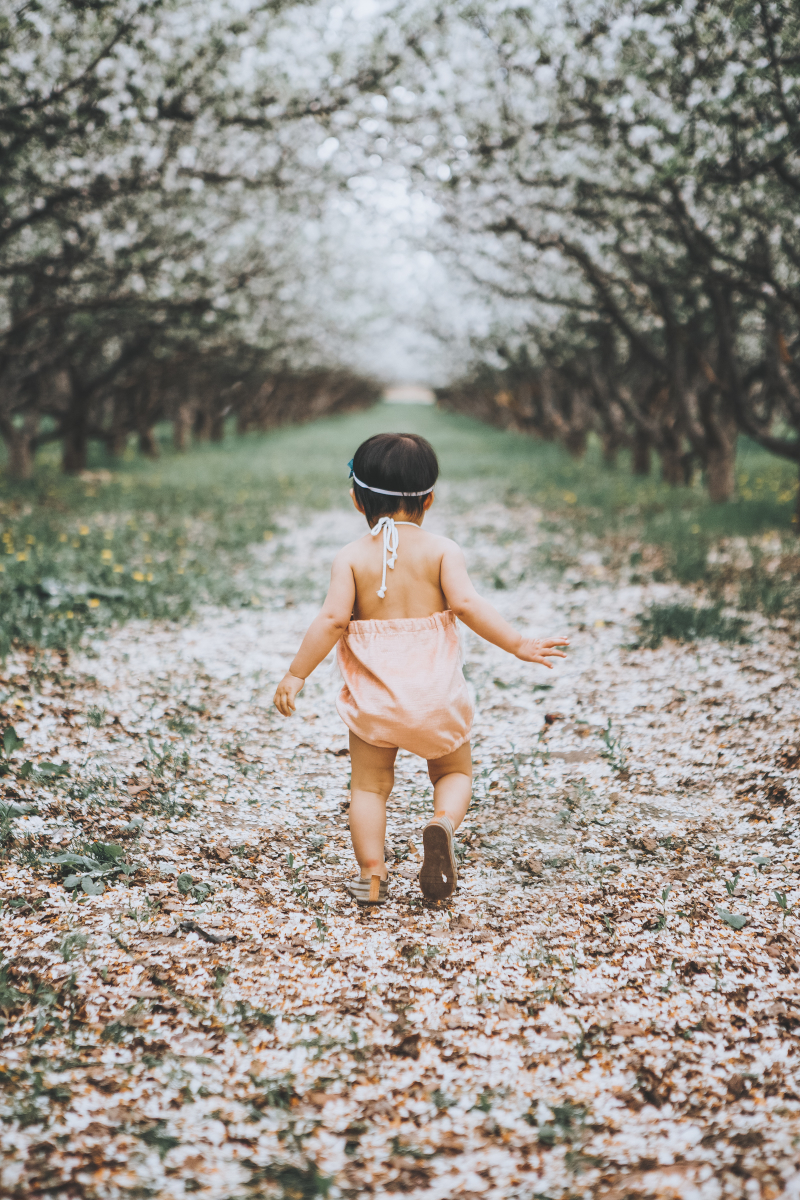 Baby girl running through Provo Orchards